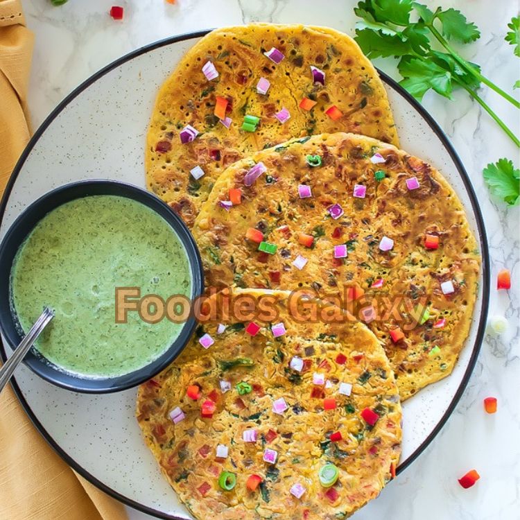 Golden brown besan chilla served with green mint chutney