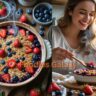 mixed berry crumble with strawberries and blueberries in a rustic dish, showing golden oat topping and fresh berries on a wooden kitchen table